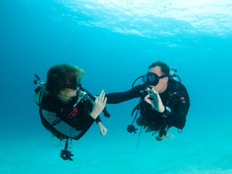 Instructor and student, giving each other 'Okay' signal, Mabul, Sabah, Malaysia